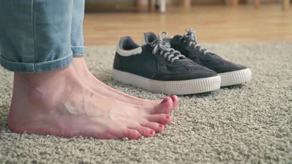 Women's Feet and Sneakers on the Carpet alt