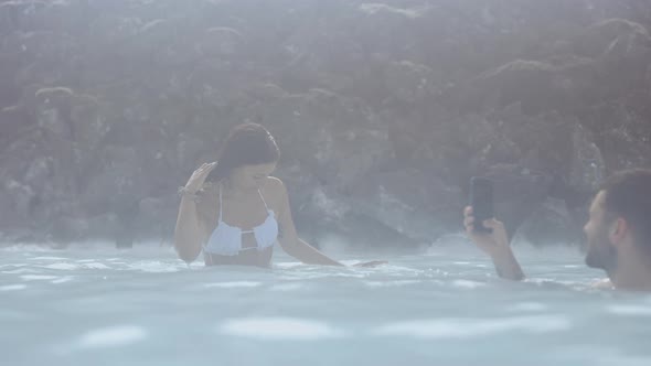 Woman In Bikini And Boyfriend With Phone In Lagoon alt