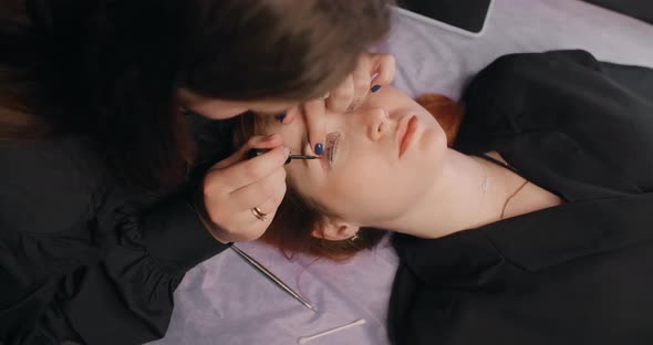 Lashmaker Does the Eyelash Lamination Procedure for the Client in the Beauty Salon Cosmetic Services alt