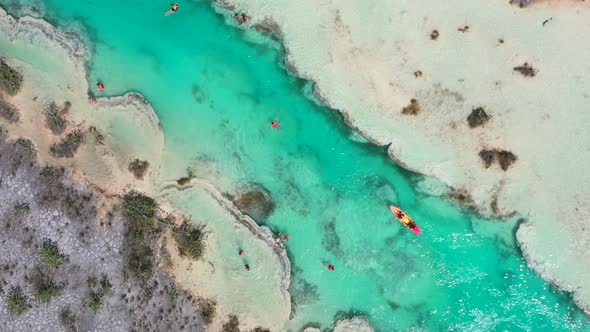 kayak and tourists at the turquoise blue Los Rapidos rapids in Bacalar Mexico, aerial top down alt