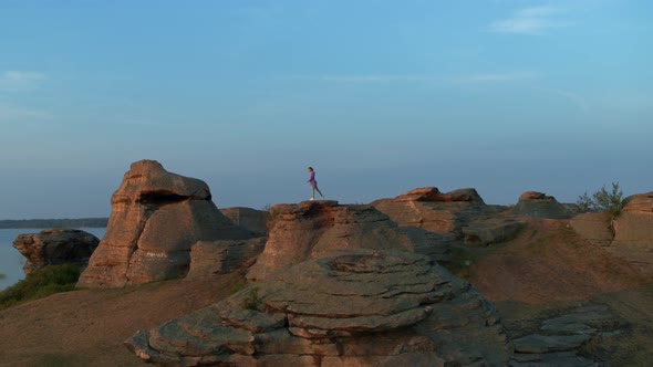 A Girl is Doing Fitness on a Hill on the Lake Shore alt