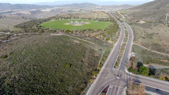 Aerial Top View of Community Park Baseball Sports Field Next To Small Road in a Green Valley alt