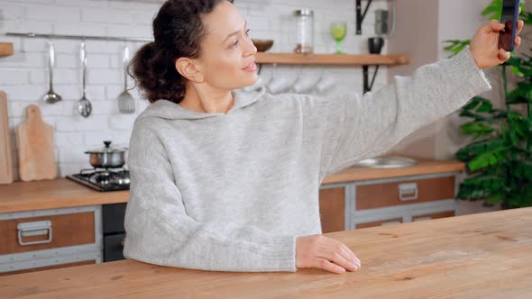 Happy Brunette Messaging with Friend By Mobile alt