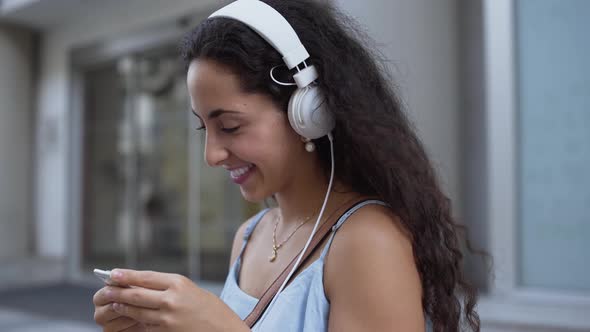 Smiling Young Woman with Headphones Having Fun Listening To Podcast