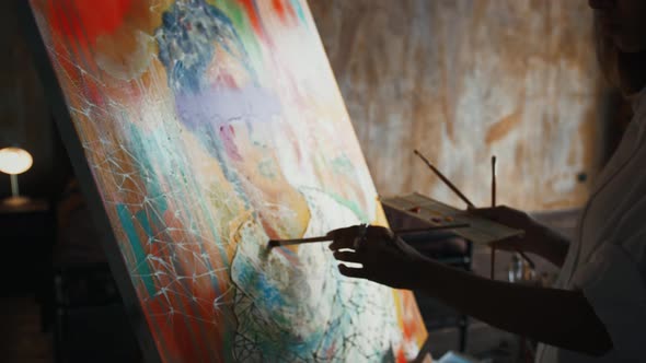Young Lady Artist is Painting a Portrait on Canvas in Concept Art Style While Working at Home alt