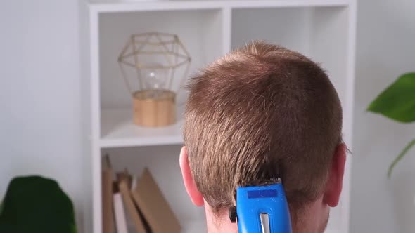 A Man Cuts His Hair with Clipper