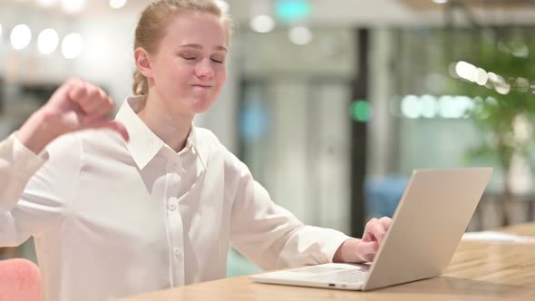 Disappointed Young Businessman with Laptop Doing Thumbs Down alt