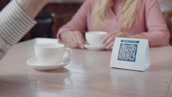 Close Up of Man Scan Qrcode Wth Smartphone and Pay in Restaurant alt