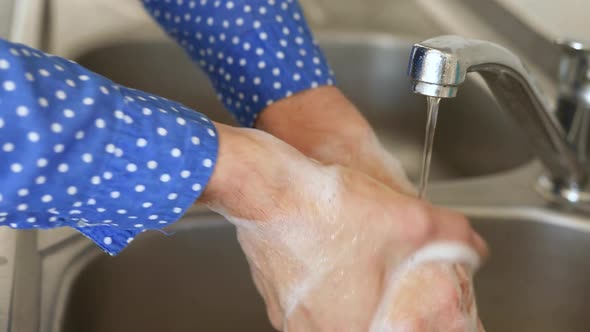 Caucasian woman washing her hands with soap at home alt