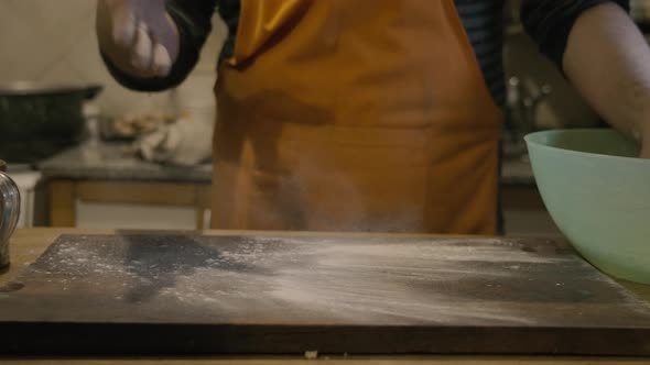 Chef dusting the table with flour slowmotion