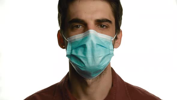 Portrait of a Young Man in a Medical Mask on a White Background Isolate