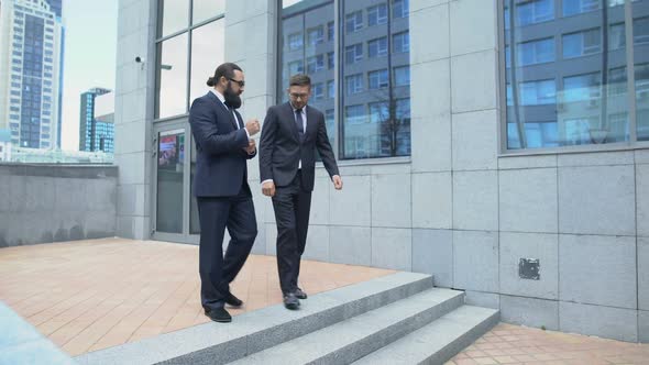 Confident Business Partners Exiting From Office Building and Communicating