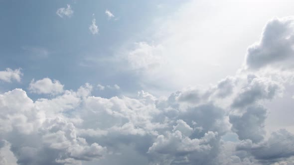 Wide angle of clouds slowly moving across a clear blue sky alt