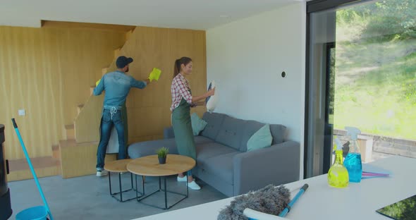 Positive Smiling Professional Cleaners Doing Cleanup in Ordinary Apartment. alt