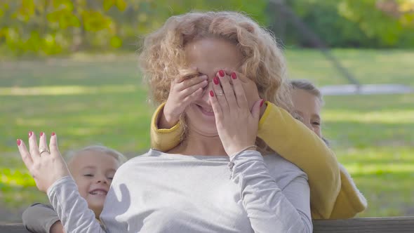 Close-up Portrait of Young Caucasian Curly Blond Woman Sitting on the Bench in the Autumn Park alt