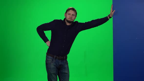 Man Leaning Hand on Wall Standing Against Chroma Key Background alt