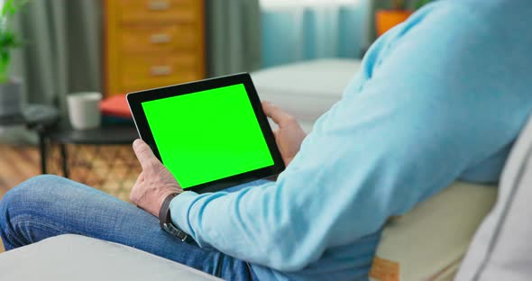 Close Up of Digital Tablet with Blank Green Mock Up Screen Display Hold By Old alt