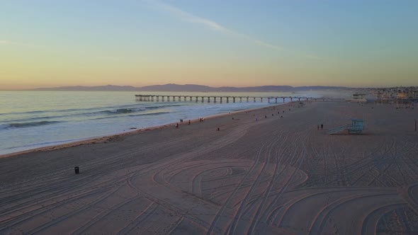 Aerial drone uav view of a pier at sunset at the beach and ocean. alt