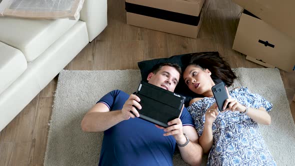 Happy Couple in Their New Flat Lying Down alt