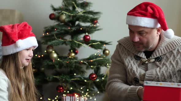 Dad Giving His Little Daughter Christmas Gift Indoors alt