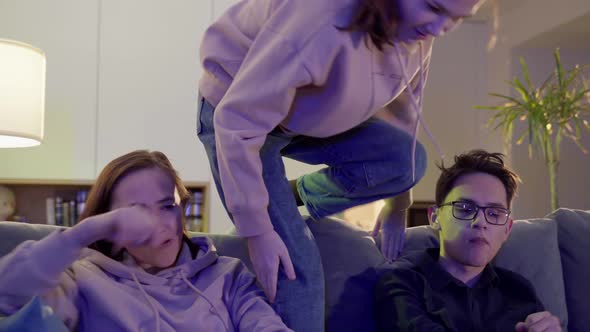 Mom and Teenage Son are Watching TV Sitting on the Couch alt