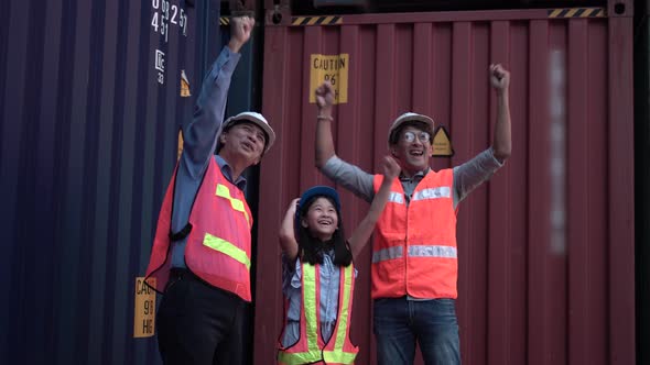 Family visiting cargo containers site, Father daughter and senior engineers celebrating in shipyard
