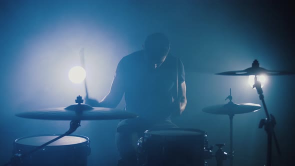 Silhouette of Professional Drummer Plays a Drums in Smoky Studio Slow Motion alt