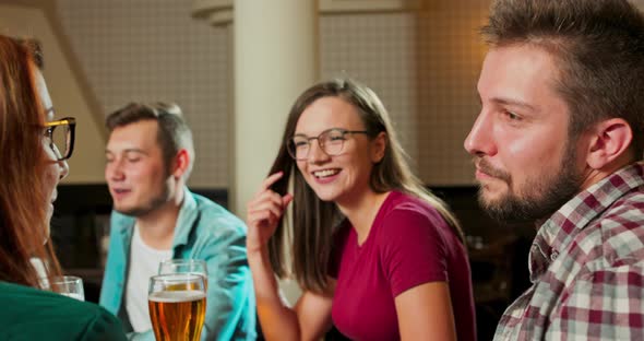 Friends Laugh Drink Beer and Cocktails While Having a Good Time Together at a Bar alt