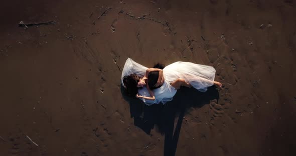 Young Woman Covered with Black White Cloth on Sand Beach alt