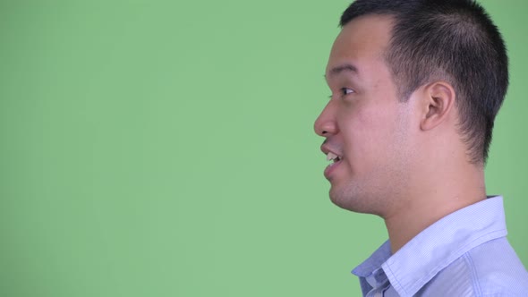 Closeup Profile View of Happy Asian Businessman Talking alt