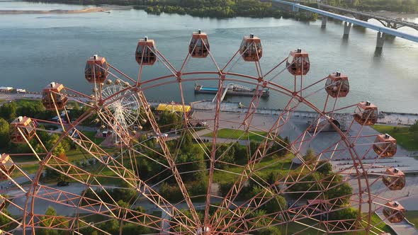 Drone View Colorful Ferris Wheel in Amusement Park on River and City Landscape alt