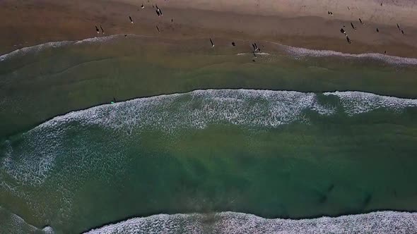 Slow motion aerial footage of waves rolling into the beach in Southern California alt