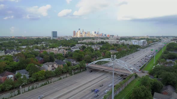 Aerial view of affluent neighborhood near freeway with downtown Houston in the background. This vide alt