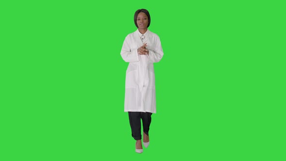 Young African American Female Doctor Talking As She Walks on a Green Screen, Chroma Key. alt