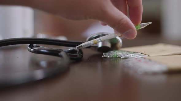 Closeup Stethoscope and Ampoules on Table with Female Caucasian Hand Putting Covid19 Vax in Slow alt