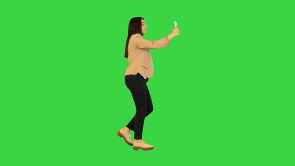 Young Indian Girl Walking and Making a Video Call on a Green Screen Chroma Key