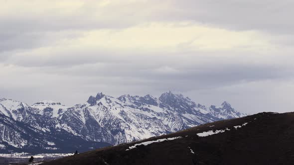 Snow Storm weather clouds rolling in over rocky mountain range with Grand Tetons in national park Pr alt