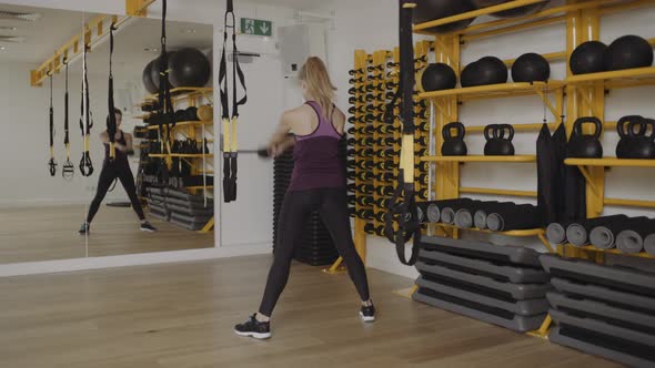 Young woman lifting weights exercise in gym