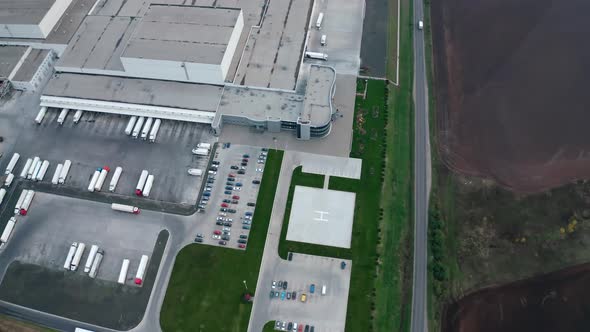 Industry near the road. Parking zone with cars and trucks on the industrial territory on field.  alt