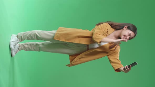 Full Body Of The Smiling Asian Woman Making Selfie While Standing On Green Screen In The Studio alt