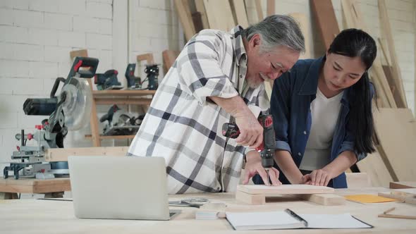 Carpenter use electric drill to drill wood alt