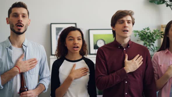 Young Patriots Standing Singing Anthem at Home Before World Sports Games on TV alt
