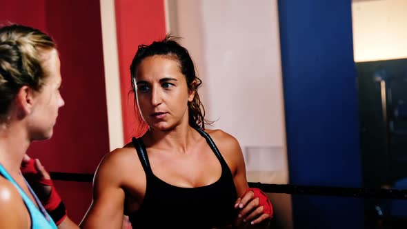 Female boxers interacting with each other during break alt