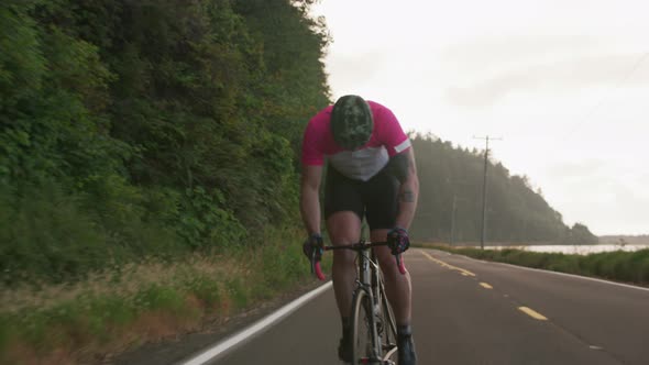 Tracking shot of a male cyclist on country road.  Fully released for commercial use.