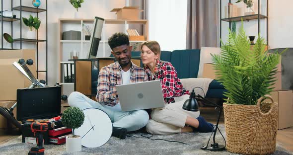 Couple Sitting on the Floor in their New Apartment During Relocation and Planning design alt