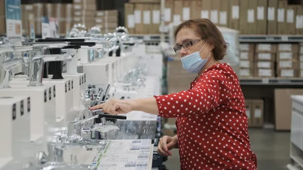 Senior Woman Choosing Water Tap in Plumbing Store alt