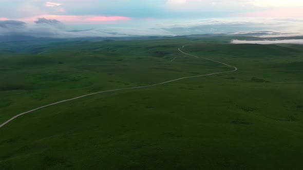 Aerial view on the beautiful summer landscape with country road and green fields