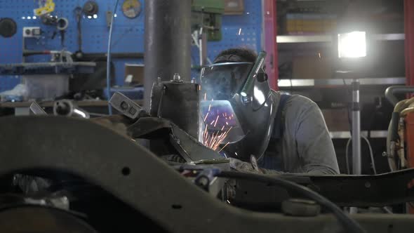Welding Process. Welder In Helmet Works, Worker Works In The Auto Workshop.