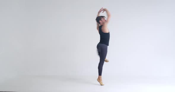 Young Man Dancer Performs Acrobatic Elements of a Ballet Dance on a White Background alt