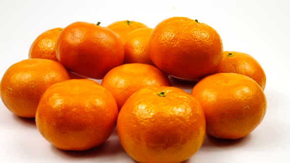 Ripe tangerines lie on a turntable against a white background
